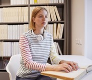 photo of a woman reading a braille publication