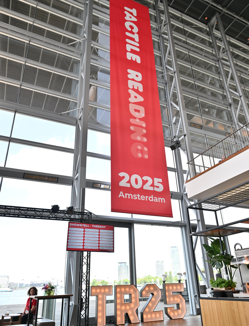 photo from the Tactile Reading 2025 event showing a branded banner