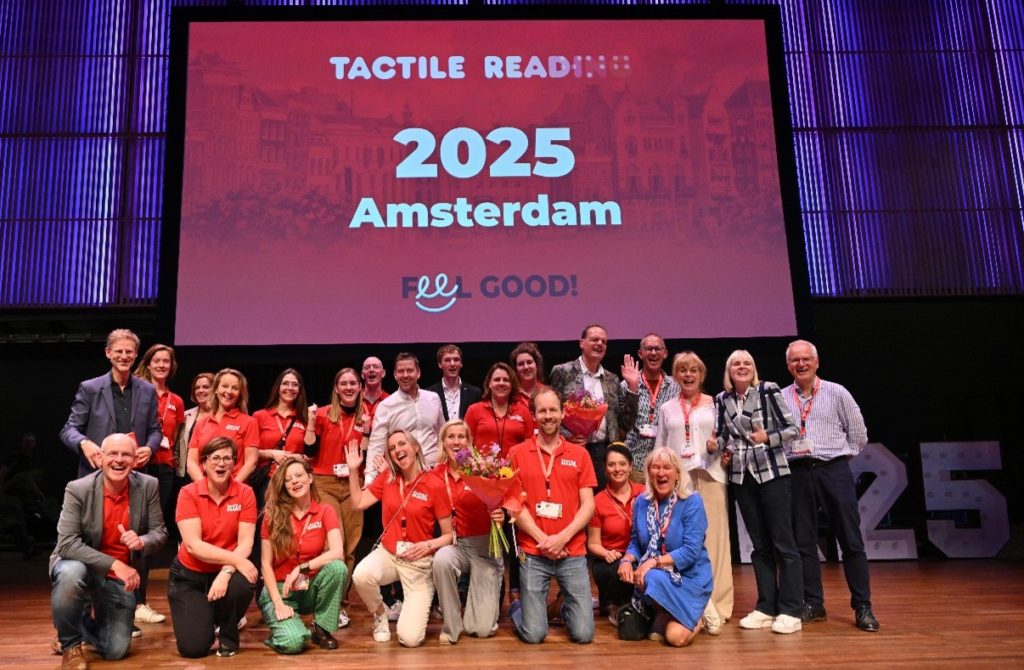 photo of 24 people on stage under the Tactile Reading 2025 graphic